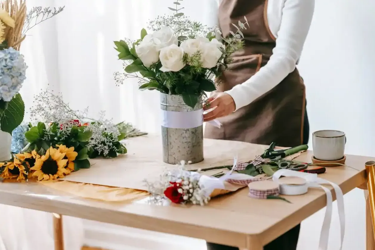 Florystka wiążąca bukiet róż w pracowni